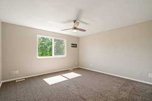 Spare room featuring carpet flooring and ceiling fan