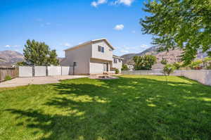 Exterior space with a patio area, a mountain view, an outdoor fire pit, and a front yard