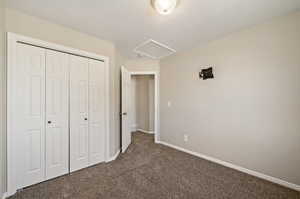 Unfurnished bedroom featuring dark carpet and a closet