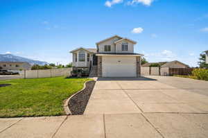 View of front of property with a mountain view, a garage, and a front yard