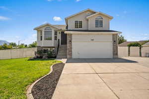 Tri-level home featuring a front yard and a garage