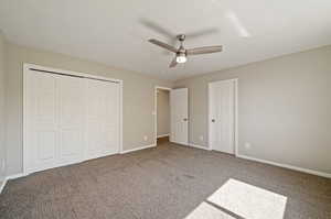 Unfurnished bedroom with carpet flooring, ceiling fan, and a closet