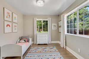 Bedroom featuring multiple windows and dark hardwood / wood-style floors