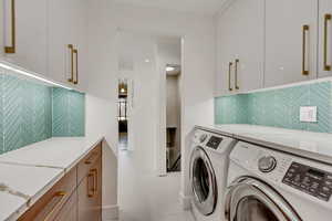 Laundry room shares kitchen style. Walnut cabinets, quartz countertops, glass backsplash.