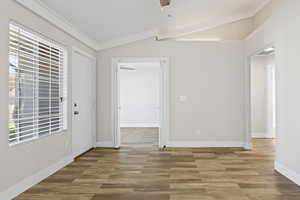 Entryway with ornamental molding, lofted ceiling, and LVP flooring