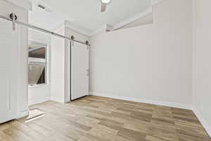 Master bedroom featuring ceiling fan, and a barn door