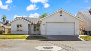 Ranch-style home featuring a front lawn and a garage