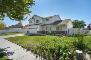 View of front of home featuring a garage and a front lawn