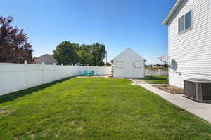 View of yard with cooling unit and a shed