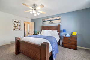 Carpeted bedroom featuring ceiling fan and a textured ceiling