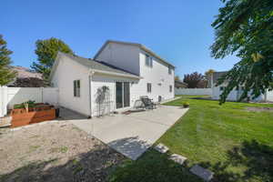 Back of house featuring a lawn and a patio