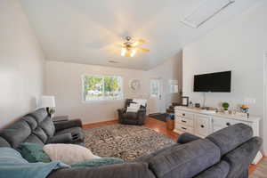 Living room with lofted ceiling, light hardwood / wood-style flooring, and ceiling fan