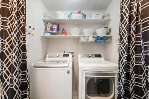 Laundry area featuring a textured ceiling and washing machine and dryer