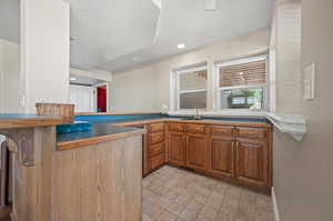 Kitchen with a textured ceiling, kitchen peninsula, and sink