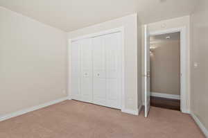 4th bedroom featuring a closet and light carpet