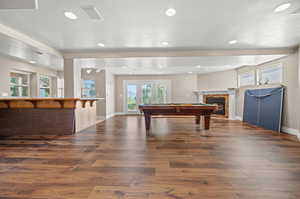 Playroom featuring dark hardwood / wood-style floors, pool table, french doors, and a fireplace