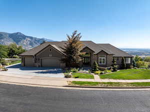 View of front of home with a mountain view, a garage, and a front yard