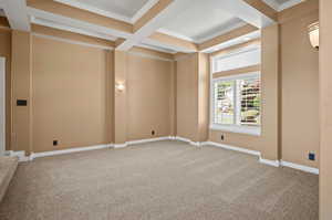 Carpeted empty room with coffered ceiling, beam ceiling, and ornamental molding