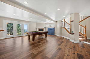 Playroom featuring billiards, dark hardwood / wood-style floors, and a textured ceiling