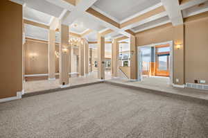 Unfurnished living room featuring coffered ceiling, an inviting chandelier, carpet floors, and beam ceiling