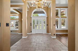 Entrance foyer featuring crown molding, a healthy amount of sunlight, and a notable chandelier