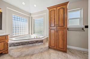 Master Bathroom featuring tiled tub and vanity