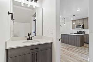 Bathroom with hardwood / wood-style floors, tasteful backsplash, and vanity