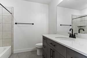 Full bathroom with tiled shower / bath combo, vanity, toilet, and tile patterned flooring