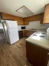 Kitchen with a textured ceiling, light wood-type flooring, sink,  upgraded dishwasher, and microwave included.