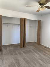 Larger bedroom with a wall mounted A/C unit  and  ceiling fan,  carpet flooring,