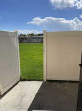 View of gate accessing the  large outdoor common area with BBQ and Gazebo