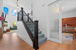 Stairs featuring hardwood / wood-style flooring and a towering ceiling