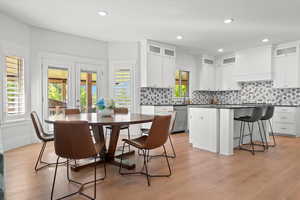 Dining area featuring light wood-type flooring, sink, and a healthy amount of sunlight