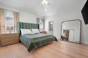 Master Bedroom featuring lofted ceiling, light hardwood / wood-style flooring, connected bathroom, and ceiling fan