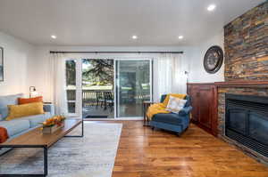 Living room with hardwood / wood-style floors and a stone fireplace