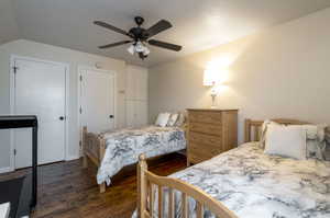 Bedroom with ceiling fan, dark hardwood / wood-style floors, and vaulted ceiling