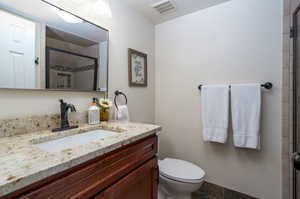 Bathroom featuring an enclosed shower, tile patterned flooring, toilet, and vanity