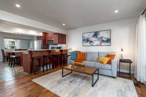 Living room with sink and wood-type flooring