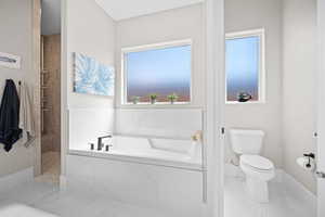 Bathroom featuring tile patterned flooring, separate shower and tub, and toilet