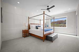 Carpeted bedroom with ceiling fan and ornamental molding