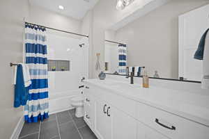 Full bathroom featuring vanity, toilet, tile patterned floors, and shower / bathtub combination with curtain