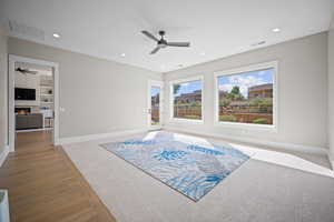 Living area with ceiling fan and light hardwood / wood-style floors