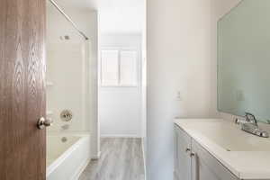 Bathroom featuring bathtub / shower combination, hardwood / wood-style flooring, and vanity