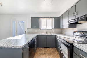 Kitchen featuring black appliances, backsplash, sink, and gray cabinetry