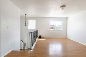 Spare room featuring a textured ceiling and light hardwood / wood-style flooring