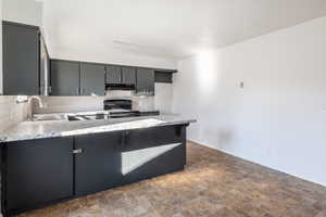 Kitchen featuring backsplash, kitchen peninsula, sink, gray cabinets, and black range with electric cooktop