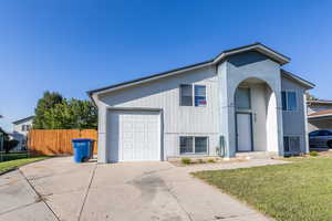 View of front of property with a front yard and a garage