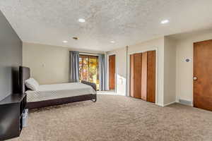 Carpeted bedroom featuring a textured ceiling