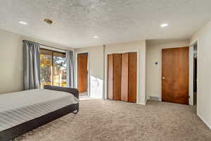 Bedroom featuring a closet, carpet, and a textured ceiling