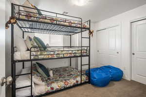 Bedroom featuring carpet floors, a textured ceiling, and a closet